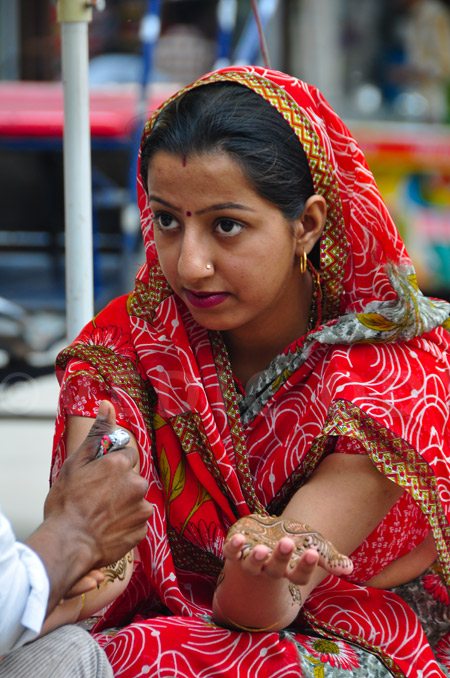 Girl gets henna done on her hands by an artists